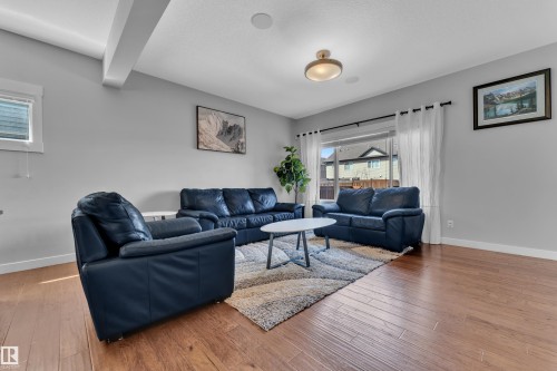 Living area featuring hardwood flooring, light grey walls, and ample natural light from the large window - 6406 169 Avenue, Edmonton, AB - Indoor Photo Showing Living Room