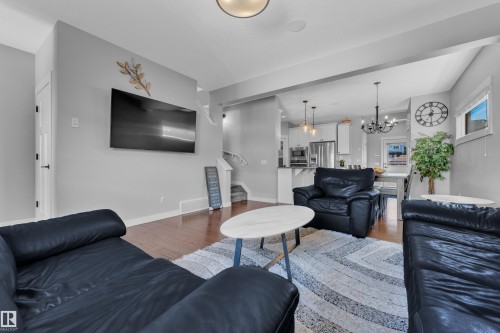 The living area features hardwood floors and light gray walls, with recessed lighting and a contemporary ceiling fixture - 6406 169 Avenue, Edmonton, AB - Indoor Photo Showing Living Room