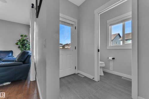 The property features a entryway with a white door and an interior space with a toilet and window - 6406 169 Avenue, Edmonton, AB - Indoor Photo Showing Other Room