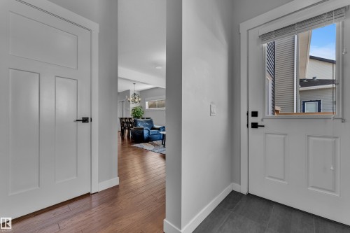 Entryway featuring a white door with a window, modern dark hardware, and a tiled floor - 6406 169 Avenue, Edmonton, AB - Indoor Photo Showing Other Room