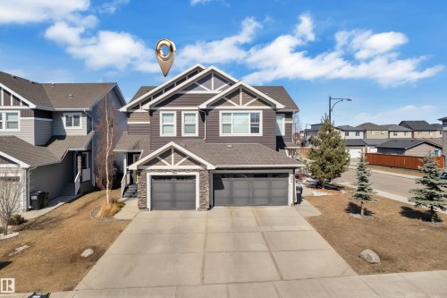 The property features a dark-toned exterior with light trim accents, a two-car garage, and a concrete driveway - 6406 169 Avenue, Edmonton, AB - Outdoor With Facade