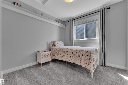 This room features light grey walls, grey carpet, a window with grey curtains, and a high display shelf - 6406 169 Avenue, Edmonton, AB - Indoor Photo Showing Bedroom