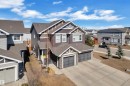 The property features a dark-toned exterior with stone accents and a prominent two-car garage - 6406 169 Avenue, Edmonton, AB  - Outdoor With Facade 