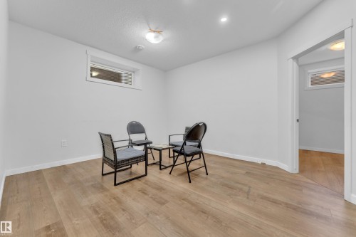 Spacious room featuring light wood flooring, white walls, and a window with horizontal blinds - 6406 169 Avenue, Edmonton, AB - Indoor Photo Showing Other Room