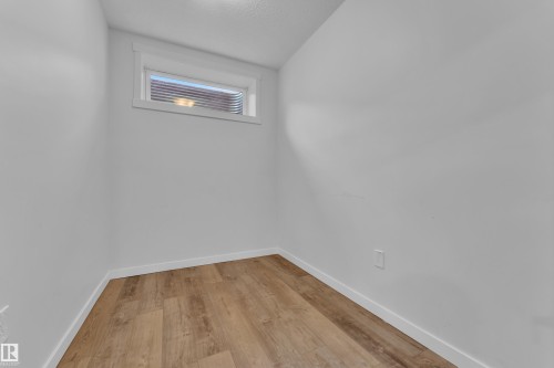This room features light wood-style flooring and white walls, creating a bright and airy atmosphere - 6406 169 Avenue, Edmonton, AB - Indoor Photo Showing Other Room