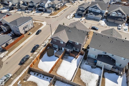 Aerial view showcasing the property's dark exterior, fenced backyard, and wooden deck - 6406 169 Avenue, Edmonton, AB - Outdoor With View