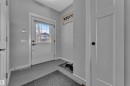 The property features a bright entryway with a white door, an integrated window, and a modern black door handle - 6406 169 Avenue, Edmonton, AB  - Indoor Photo Showing Other Room 