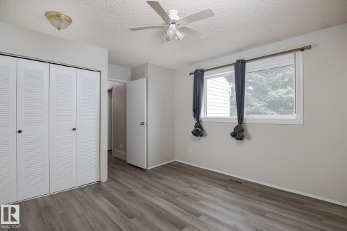 This room features durable plank flooring, a ceiling fan, and a window providing natural light - 37 Woodvale Village, Edmonton, AB - Indoor Photo Showing Other Room
