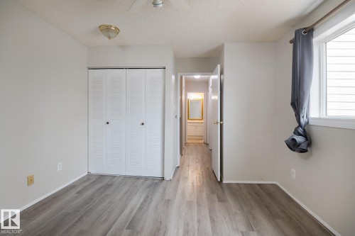 This room features light-toned walls and wood-look flooring - 37 Woodvale Village, Edmonton, AB - Indoor Photo Showing Other Room