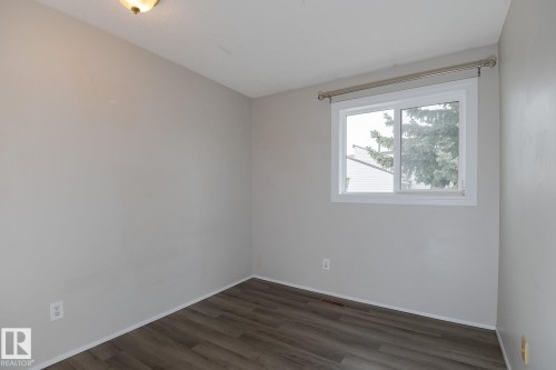 This room features a window providing natural light, light gray walls, and wood-look flooring - 37 Woodvale Village, Edmonton, AB - Indoor Photo Showing Other Room
