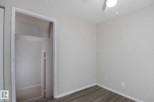 Interior room with light-colored walls, wood-style flooring, and a ceiling fan with an integrated light fixture - 37 Woodvale Village, Edmonton, AB - Indoor Photo Showing Other Room