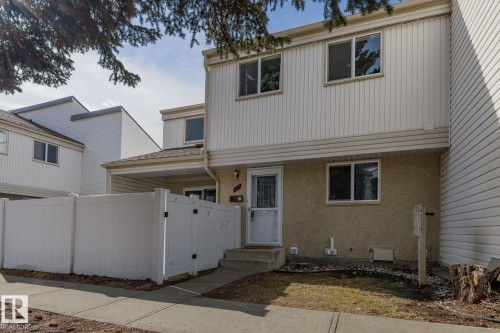 The property features a multi-level structure with light-colored siding and a covered entry - 37 Woodvale Village, Edmonton, AB - Outdoor With Exterior