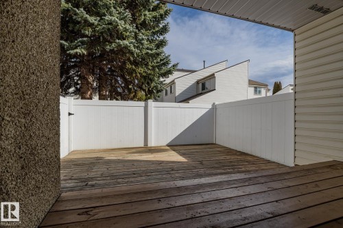 The property features a private outdoor deck area, enclosed by white fencing, providing a secluded space - 37 Woodvale Village, Edmonton, AB - Outdoor With Exterior