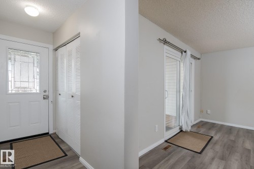 Entryway and living area featuring grey flooring, white walls, and white trim - 37 Woodvale Village, Edmonton, AB - Indoor Photo Showing Other Room