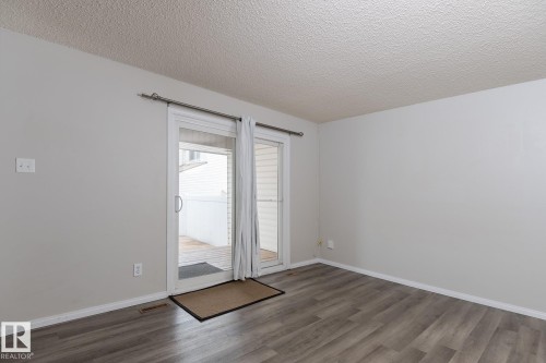 This room features light-colored walls and wood-style flooring - 37 Woodvale Village, Edmonton, AB - Indoor Photo Showing Other Room