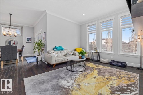 The property features rich dark hardwood floors throughout - 3908 Ginsburg Crescent, Edmonton, AB - Indoor Photo Showing Living Room