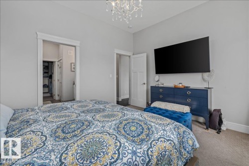 This room offers a neutral color palette, carpet flooring, and a decorative light fixture - 3908 Ginsburg Crescent, Edmonton, AB - Indoor Photo Showing Bedroom
