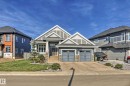 The property features a well-maintained front lawn and a paved driveway leading to a two-car garage - 3908 Ginsburg Crescent, Edmonton, AB  - Outdoor With Facade 