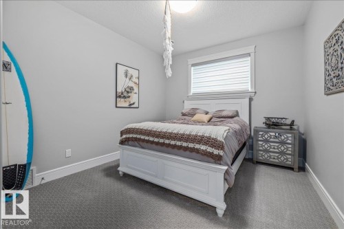 This room features light gray walls, white baseboards, and gray patterned carpeting - 3908 Ginsburg Crescent, Edmonton, AB - Indoor Photo Showing Bedroom