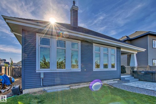 The property features an exterior with blue siding, a dark roof, and a chimney - 3908 Ginsburg Crescent, Edmonton, AB - Outdoor