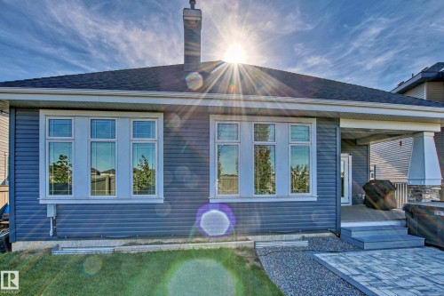 The exterior of the property features horizontal siding, a dark roof, and a chimney - 3908 Ginsburg Crescent, Edmonton, AB - Outdoor
