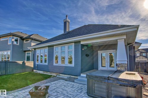 The property features a patio with pavers, a lawn area, and a fire pit - 3908 Ginsburg Crescent, Edmonton, AB - Outdoor