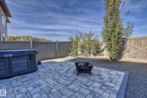 The property features a paved patio area, a fire pit, and a hot tub - 3908 Ginsburg Crescent, Edmonton, AB - Outdoor