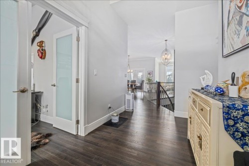 The property features dark wood flooring, white baseboards, and light grey walls - 3908 Ginsburg Crescent, Edmonton, AB - Indoor Photo Showing Other Room