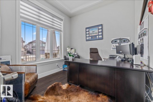 Office space with dark wood flooring and a large window featuring horizontal blinds - 3908 Ginsburg Crescent, Edmonton, AB - Indoor Photo Showing Office