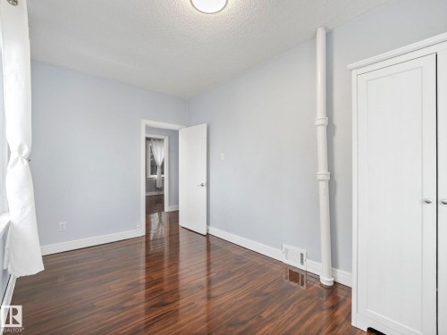 This room features rich hardwood flooring, light-colored walls, and a ceiling-mounted light fixture - 12141 96 Street, Edmonton, AB - Indoor Photo Showing Other Room