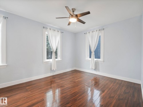 This room features hardwood flooring, light-colored walls, and a ceiling fan - 12141 96 Street, Edmonton, AB - Indoor Photo Showing Other Room