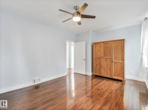 This room features polished hardwood floors and a ceiling fan with integrated lighting - 12141 96 Street, Edmonton, AB - Indoor Photo Showing Other Room