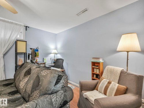 This room features light blue walls, a ceiling fan, and window with white curtains - 12141 96 Street, Edmonton, AB - Indoor