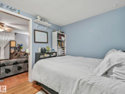 Bedroom featuring light blue walls, a ceiling light, and light-toned flooring - 12141 96 Street, Edmonton, AB - Indoor Photo Showing Bedroom
