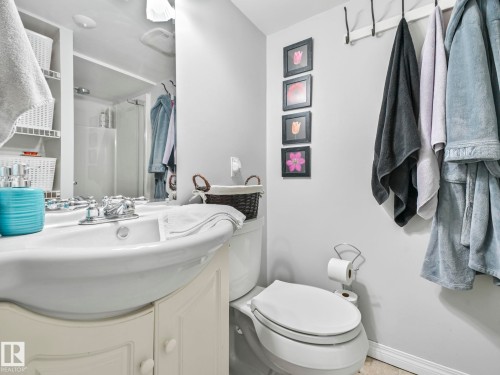 The bathroom features a white vanity with a porcelain sink, a toilet, and a shower with a clear glass enclosure - 12141 96 Street, Edmonton, AB - Indoor Photo Showing Bathroom