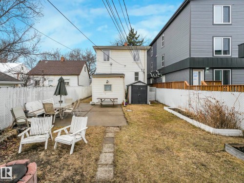 The property features a fenced backyard with a patio area and a separate shed for storage - 12141 96 Street, Edmonton, AB - Outdoor With Deck Patio Veranda