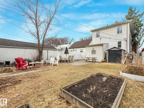 The property features a spacious backyard with a patio area, a raised garden bed, and a storage shed - 12141 96 Street, Edmonton, AB - Outdoor