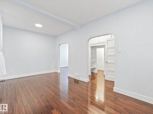 This interior space features dark wood flooring and light-colored walls - 12141 96 Street, Edmonton, AB - Indoor Photo Showing Other Room
