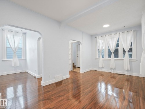 Living area featuring polished hardwood floors and light-colored walls - 12141 96 Street, Edmonton, AB - Indoor Photo Showing Other Room