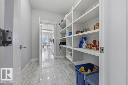 Spacious pantry featuring extensive built-in shelving and light-toned flooring - 17534 60A Street, Edmonton, AB - Indoor With Storage