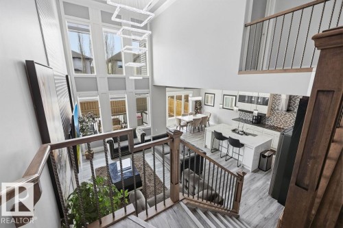 An open-concept living space featuring high ceilings, a two-story window array, and light-toned flooring - 17534 60A Street, Edmonton, AB - Indoor Photo Showing Other Room
