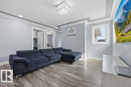 This room features light grey walls, grey wood-style flooring, and recessed lighting - 17534 60A Street, Edmonton, AB - Indoor Photo Showing Living Room