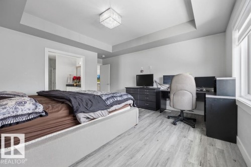 This room features light-colored flooring, a tray ceiling, and a large window - 17534 60A Street, Edmonton, AB - Indoor Photo Showing Bedroom