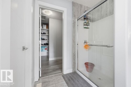 This bathroom features a shower with a clear glass enclosure and a textured wall surround - 17534 60A Street, Edmonton, AB - Indoor Photo Showing Other Room