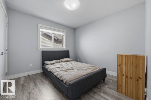 This room features modern flooring, light-colored walls, and a window with blinds providing natural light - 17534 60A Street, Edmonton, AB - Indoor Photo Showing Bedroom