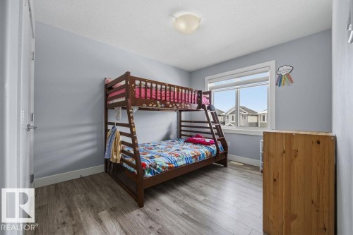 Bedroom featuring light grey walls, a window with a view of other properties, and wood-look flooring - 17534 60A Street, Edmonton, AB - Indoor Photo Showing Bedroom