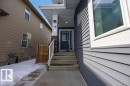 The property features a concrete pathway leading to the front entrance, which includes a dark-colored door with surrounding glass panels - 17534 60A Street, Edmonton, AB  - Outdoor With Exterior 