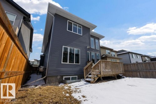 The property features grey horizontal siding, a wooden deck with railing and steps, and a fenced yard - 17534 60A Street, Edmonton, AB - Outdoor With Exterior
