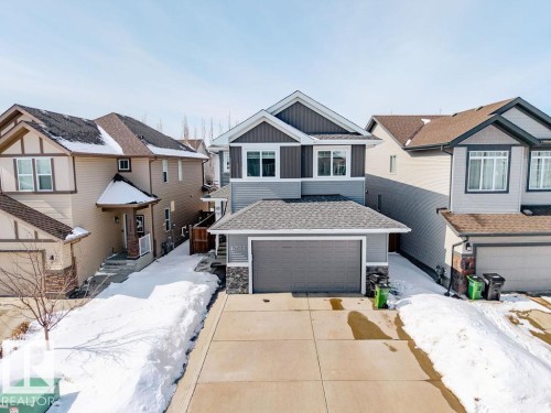 The property features a two-story exterior with a gray and dark gray facade, an attached garage, and a concrete driveway - 17534 60A Street, Edmonton, AB - Outdoor With Facade
