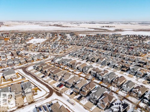 Aerial view of the neighborhood featuring a collection of properties with varied rooflines and a clear sky, bordered by snow-covered fields - 17534 60A Street, Edmonton, AB - Outdoor With View